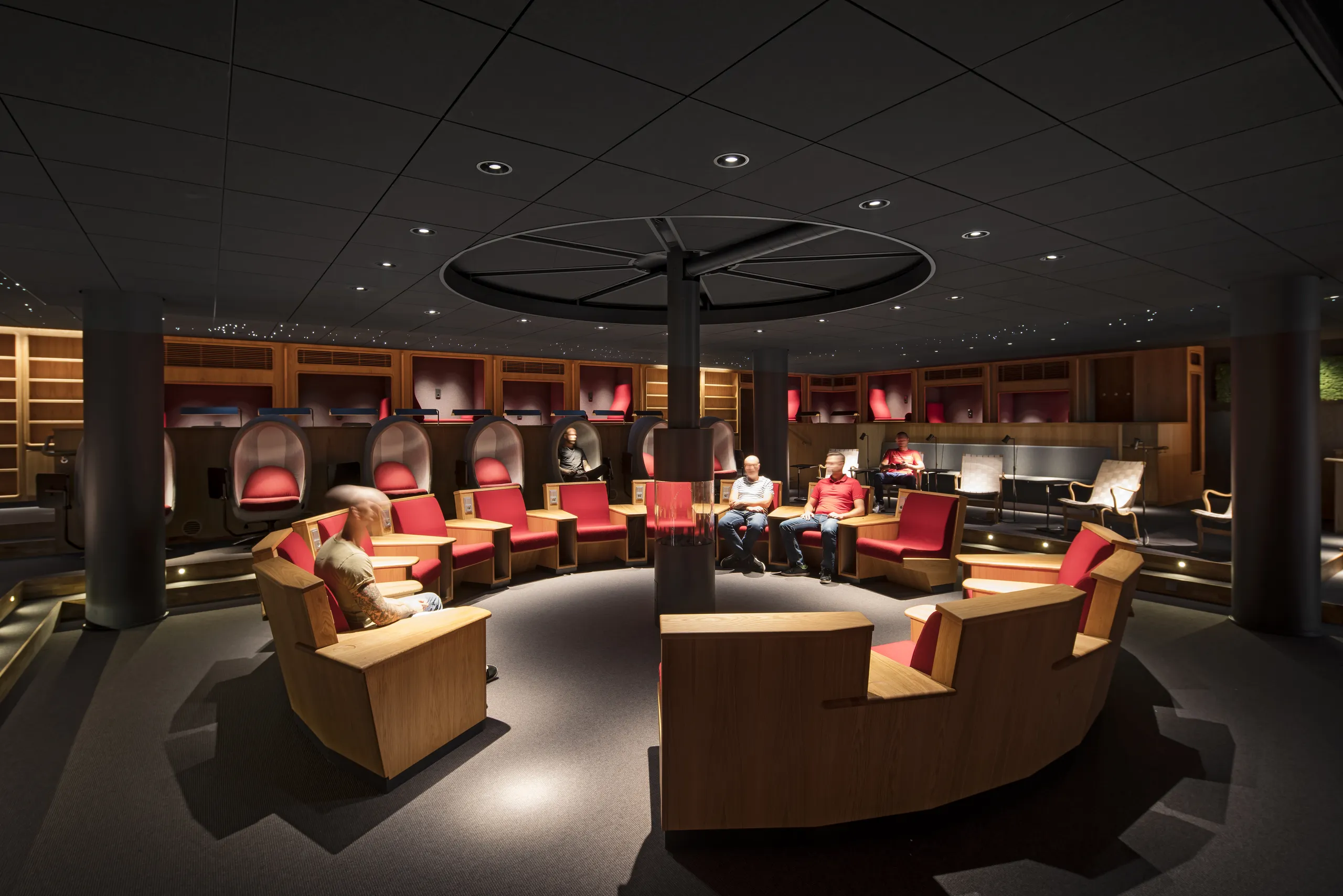 A relaxing lounge interior with a dark acoustic ceiling dotted with tiny star-effect lights, surrounding soft seating areas and timber-lined reading nooks