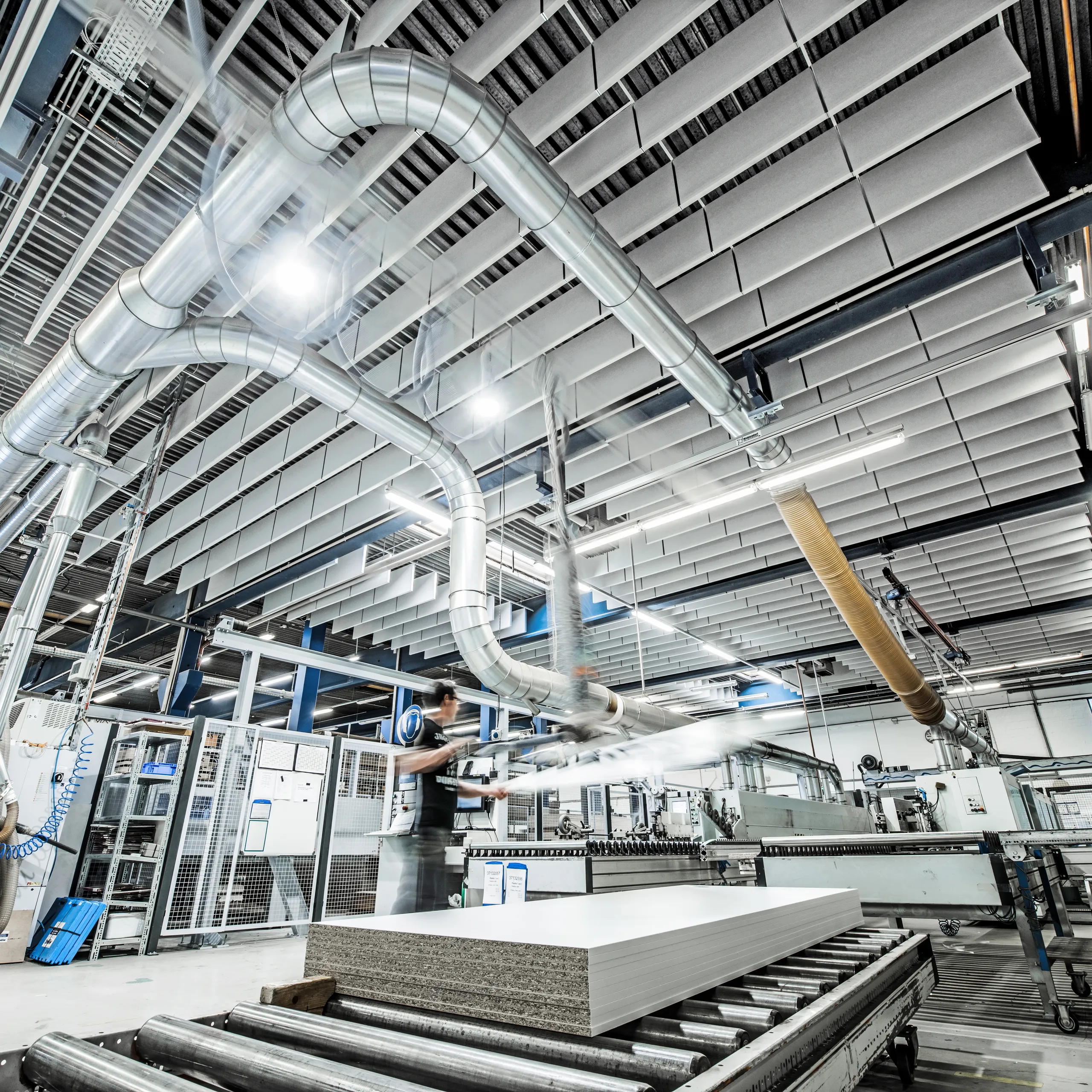 A production facility with optimised acoustics using acoustic ceiling tiles and a ceiling grid.